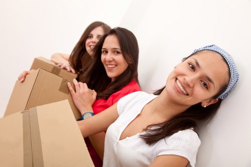Professional movers handling furniture in a Hollandpark residential street