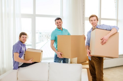 Removal staff carrying boxes through a shared residential stairwell